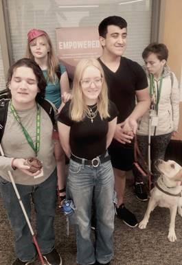 group of 5 students and guide dog smiling 